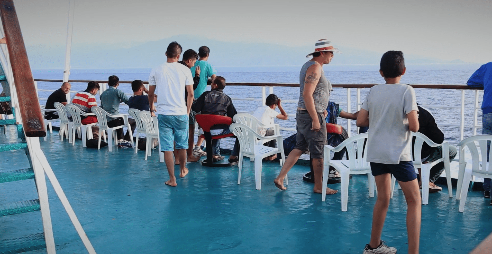 Image showing a group of people standing at the edge of a ferry boat. The image is a still from a film called NOTES ON DISPLACEMENT, a palestinian film as part of our four palestinian films available to stream free until December 23